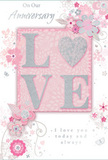 This anniversary card is a gentle celebration of long-lasting romance, its style as calm and intimate as a quiet stroll through East Sheen's tree-lined avenues near Richmond Park. The colour scheme blends soft pastel pinks with cool silvery greys, laid over a pale blush background that feels both soothing and romantic. At the centre, the word LOVE appears in raised glitter lettering, subtly textured so that each letter seems to glow when the light touches it. The O is replaced by a silver heart, its surface delicately patterned, catching highlights like a small piece of jewellery. Surrounding this focal word, graceful blossoms in blush and mauve tones unfold with the softness of watercolour. Their fine, flowing outlines and gentle shading suggest the kind of careful artistry a local florist would use when composing a spring bouquet for an anniversary dinner in East Sheen. Curving among the flowers are slender vines and flourishes, accompanied by tiny details-scattered petals, swirling lines, and faint little butterflies-that add a sense of motion and dreamy lightness. The floral design remains stylised rather than photorealistic, yet it evokes the fragrance and delicacy of an English garden in bloom. Above and below the central motif, refined script phrases read On Our Anniversary and I love you today and always, the lettering softly looping across the page without overpowering the artwork. The overall effect is that of a cherished keepsake: a card that feels like a whispered promise, marking a shared journey with tenderness and elegance, much like presenting a beautifully arranged bouquet from East Sheen Flowers on a milestone day.